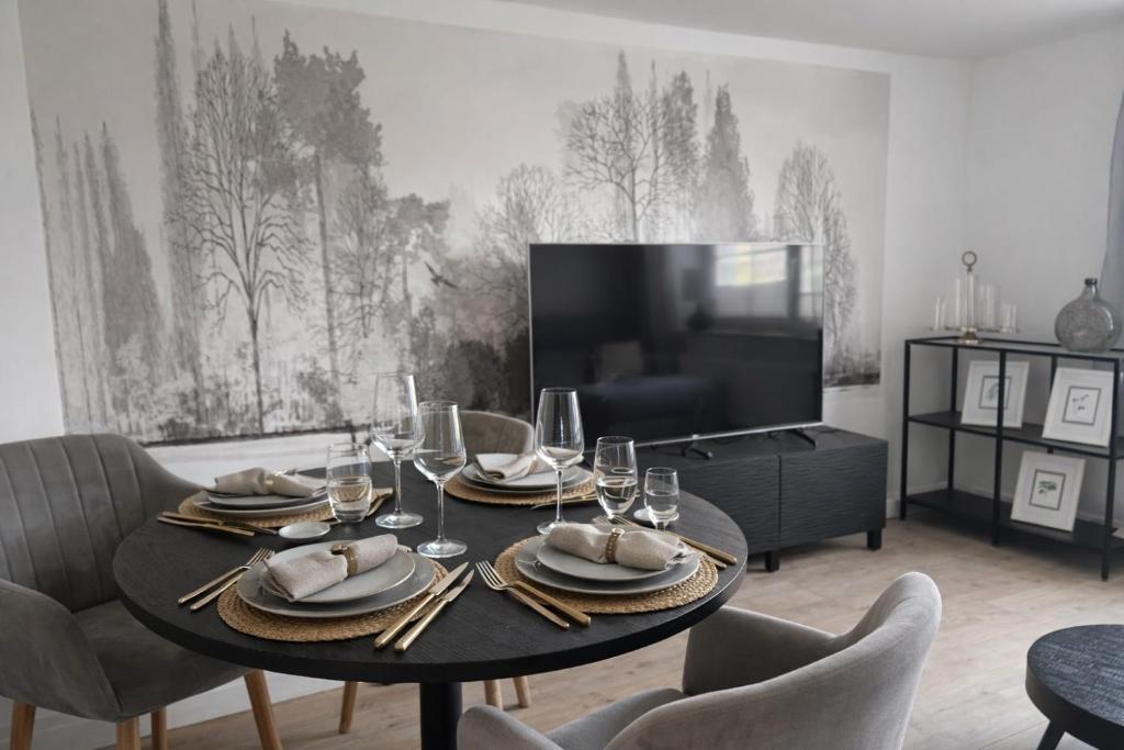 a dining room with a table with chairs and a tv at Fewo Seestern in Neukieritzsch