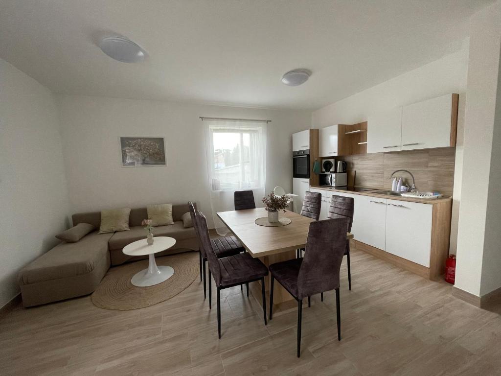 a kitchen and living room with a table and a couch at Aurum Vendégház in Esztergom