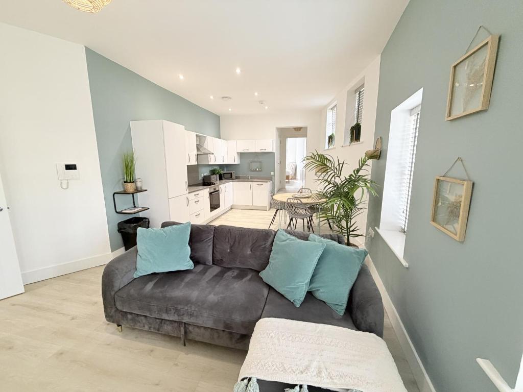 a living room with a brown couch and a kitchen at Courtyard Retreat in Southampton