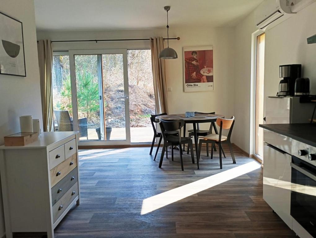 a kitchen with a table and chairs and a window at DOMA Les in Včelná