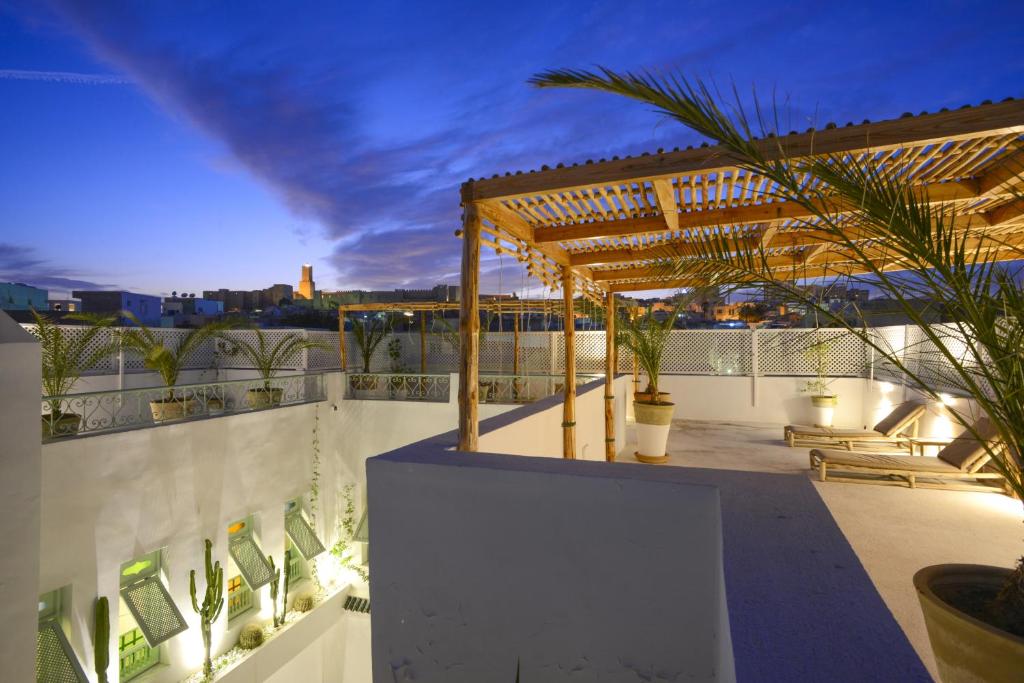 a rooftop patio with a pergola on a building at Dar Antonia in Sousse
