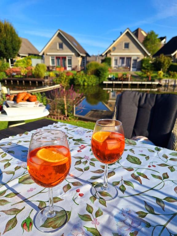 two glasses of orange juice on a table at Zoete Zee Huis in Medemblik