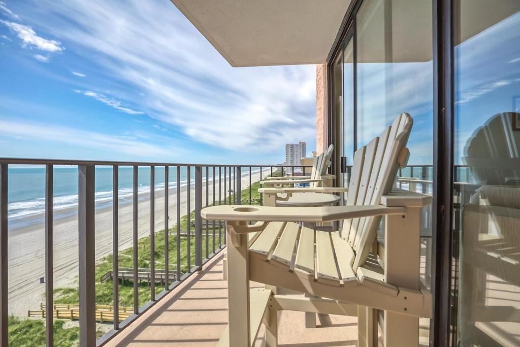 a balcony with chairs and a view of the beach at Carolina Reef #705 in Myrtle Beach