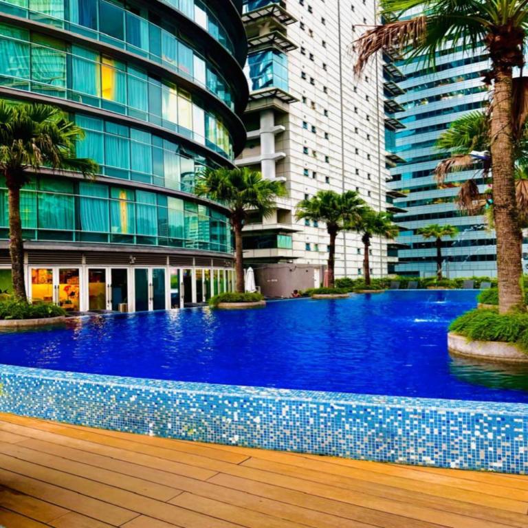 a large blue swimming pool in front of a building at Vortex Apartment klcc by HouseFull in Kuala Lumpur