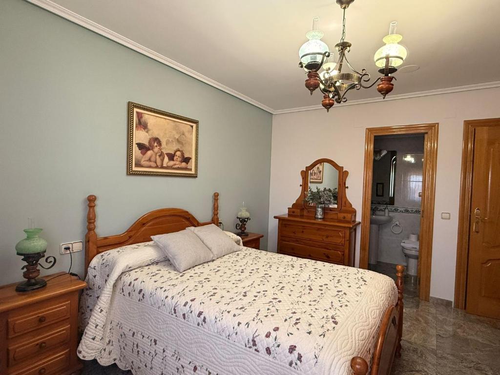 a bedroom with a bed and a chandelier at Casa Rural María Josefa in Bronchales