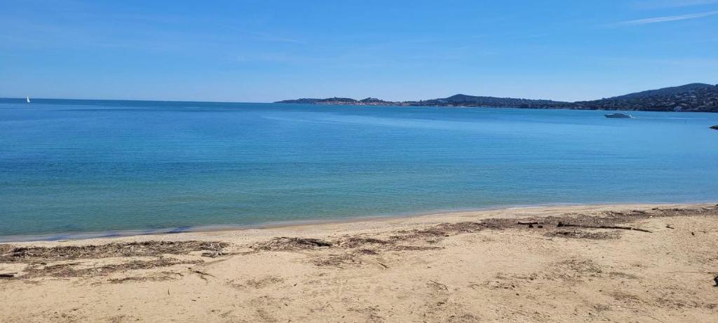 a view of the beach with a boat in the water at Port-Grimaud - La Maisonnette - sur plage et front de mer in Grimaud