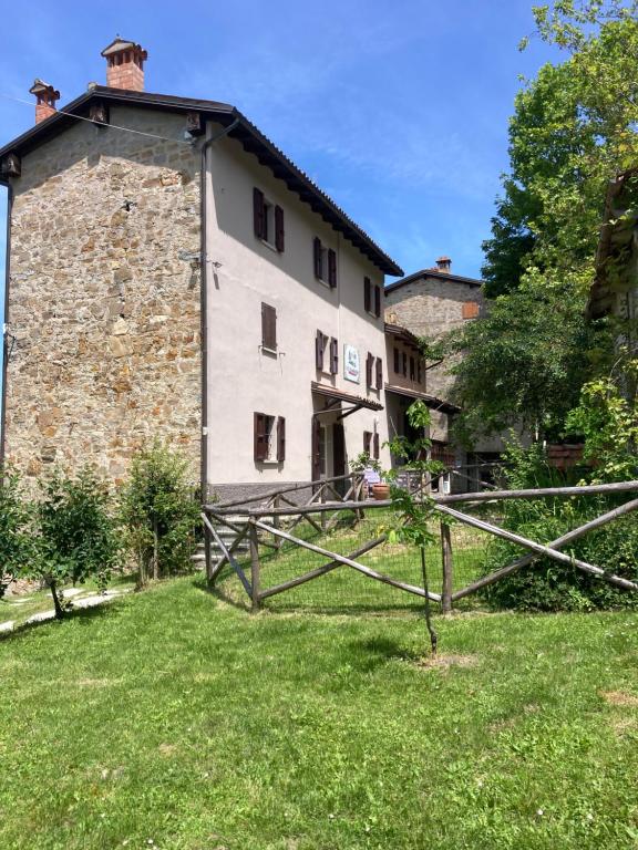 an old stone building with a gate in the grass at Villa Doubledot in Piane di Montorio