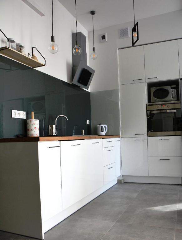 a white kitchen with green walls and white cabinets at Apartament 39 in Lublin