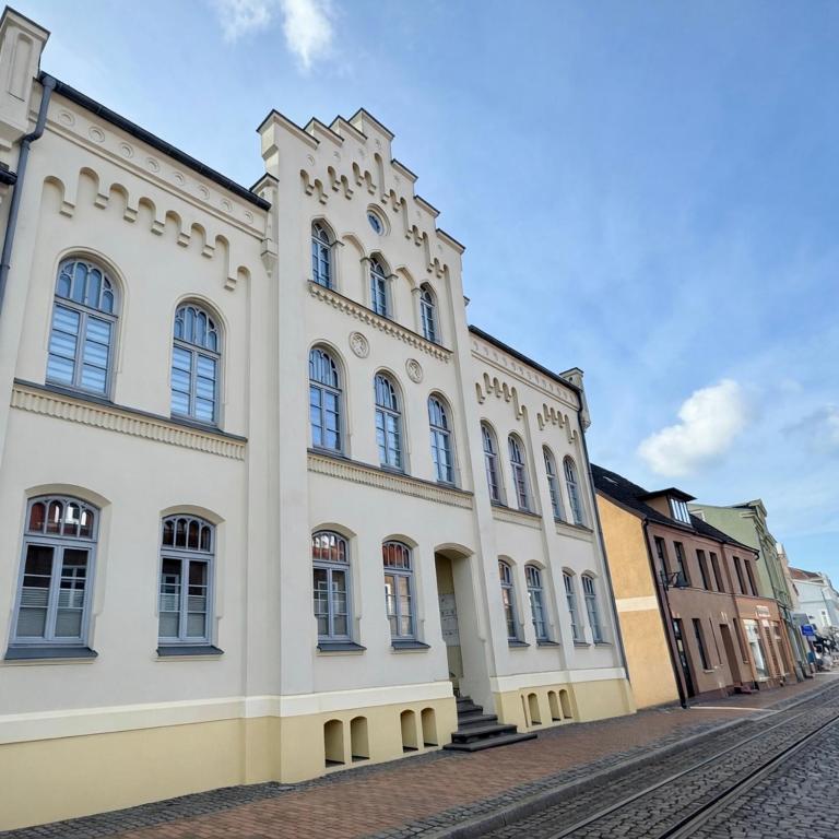 a large white building with windows on a street at Ferienwohnung Muranko in Bad Doberan