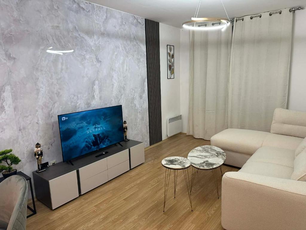 a living room with a couch and a television at Aspen Pirin View in Razlog