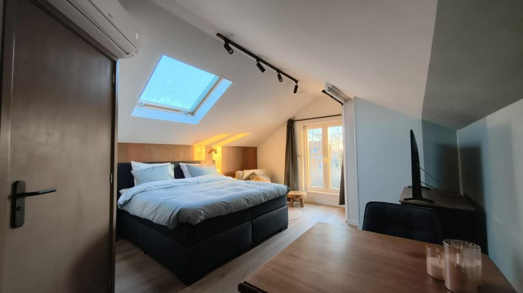 a bedroom with a bed and a skylight at Cetti's Lodge - met privé sauna in Nieuwkoop