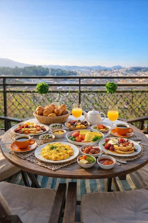 a table full of breakfast foods and drinks on a balcony at Corfu SKYLINE RESIDENT 360 in Corfu