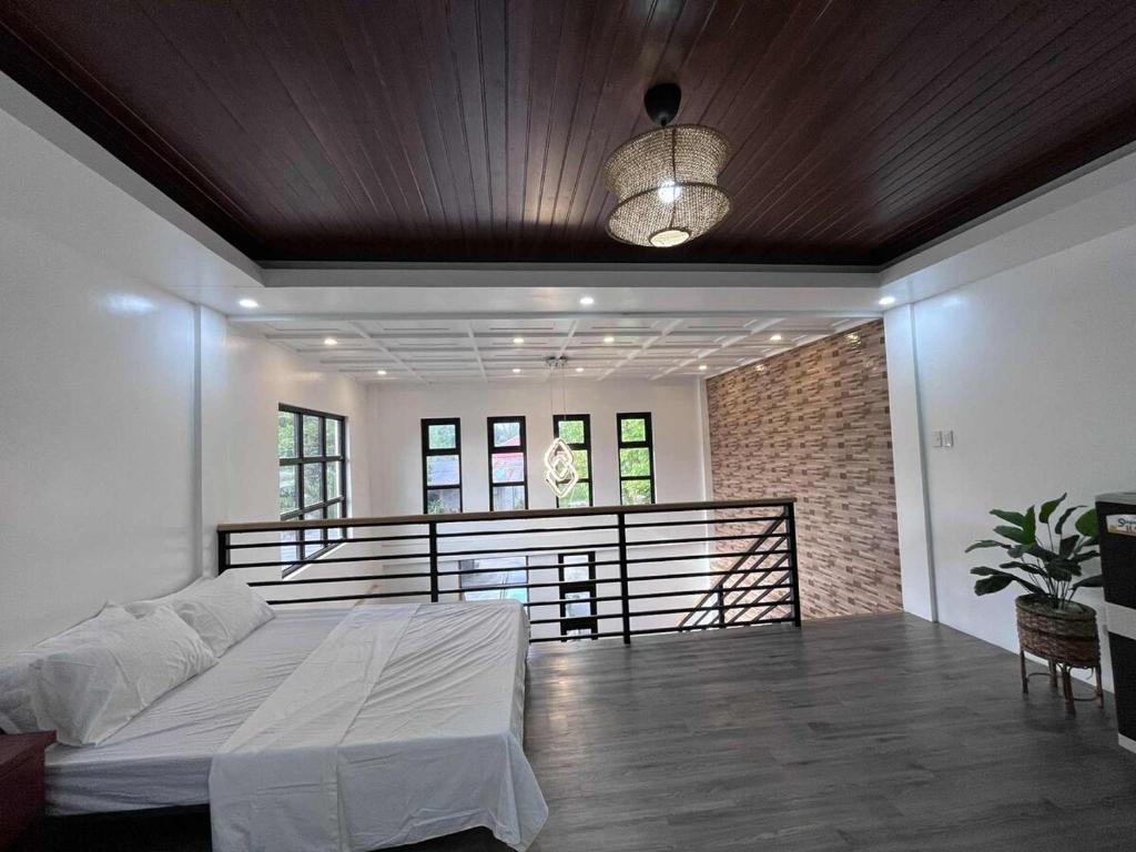 a bedroom with a bed and a balcony at The Guest House Zambales in Cabangan