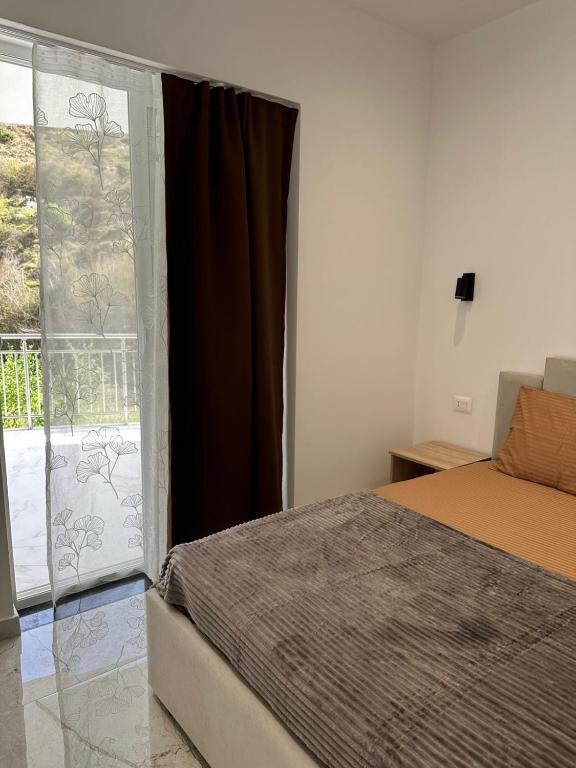 a bedroom with a bed and a large window at Qyteza guest house in Shkodër
