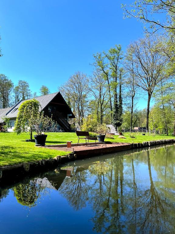a park bench sitting next to a pond in a park at Ferienwohnungen Ast in Burg