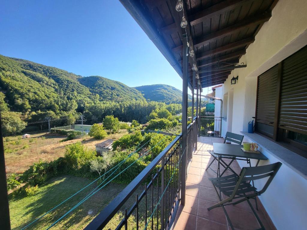 a balcony with chairs and a view of mountains at Casa La Candela in Montemayor del Río
