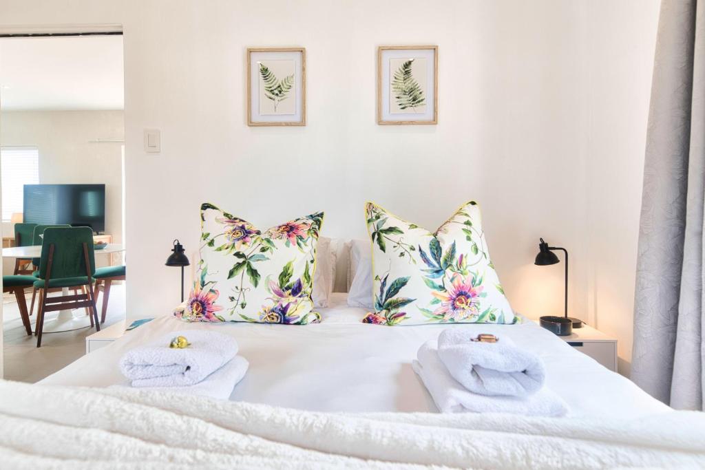 a bedroom with a white bed with towels on it at Stylish, Private, Thoughtful, Spotless, Aircon, Parking in Hermanus