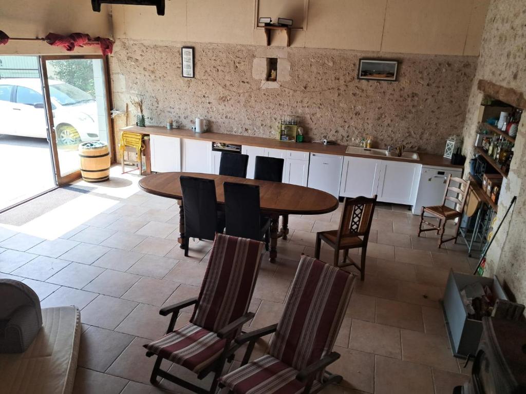 a kitchen with a table and chairs in a room at Studio 80m2 a la ferme tout confort in Courdemanche