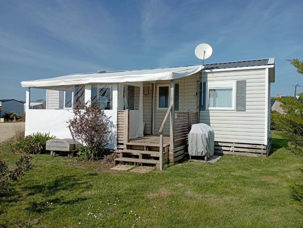 a small white house with a porch and a yard at Val'B ocean-bord de plage in Sarzeau