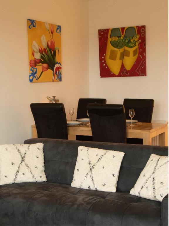 a living room with a couch and tables with chairs at Tulpenzicht in Zilk