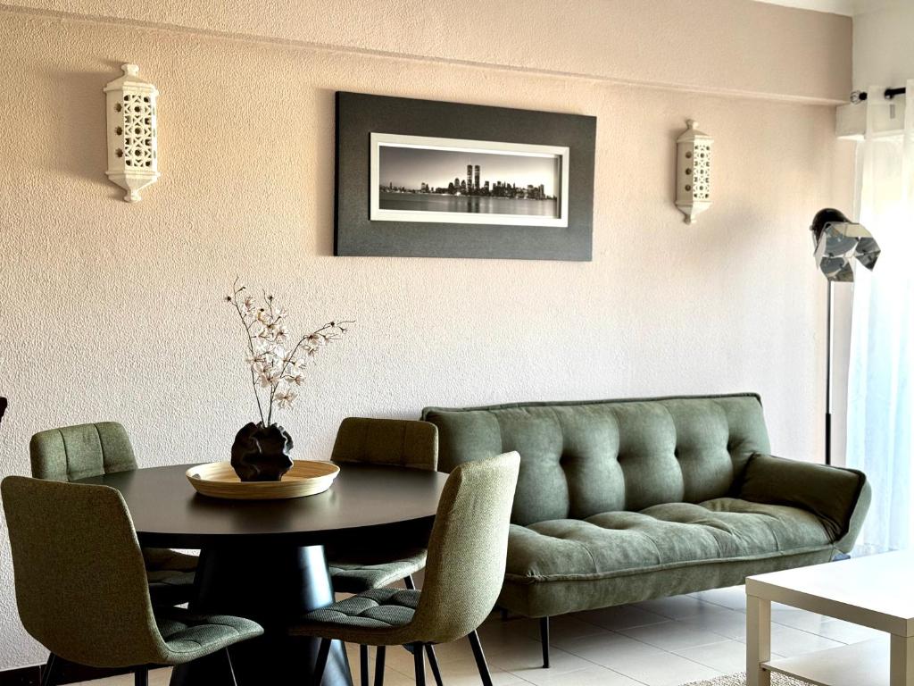 a living room with a green couch and a table at Sea House Apartment - Private Condo with 4 Pools, Jacuzzi & Tennis Court in Albufeira