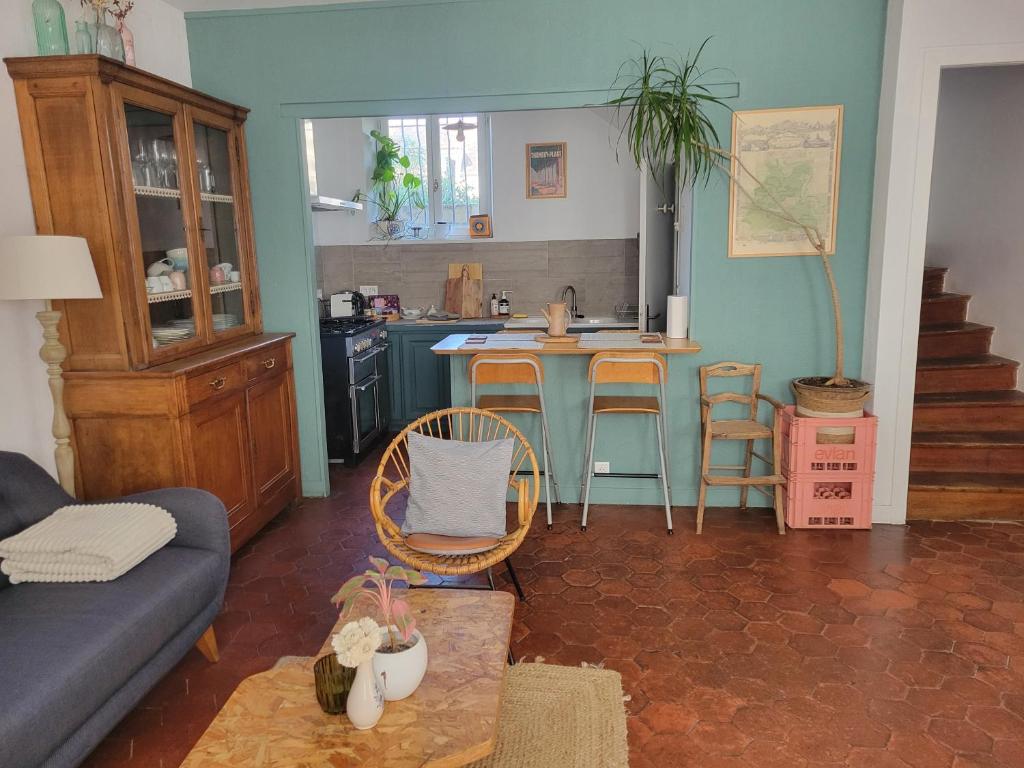 a living room with a table and a kitchen at La Bycoque, maison 2 chambres au calme in Thomery