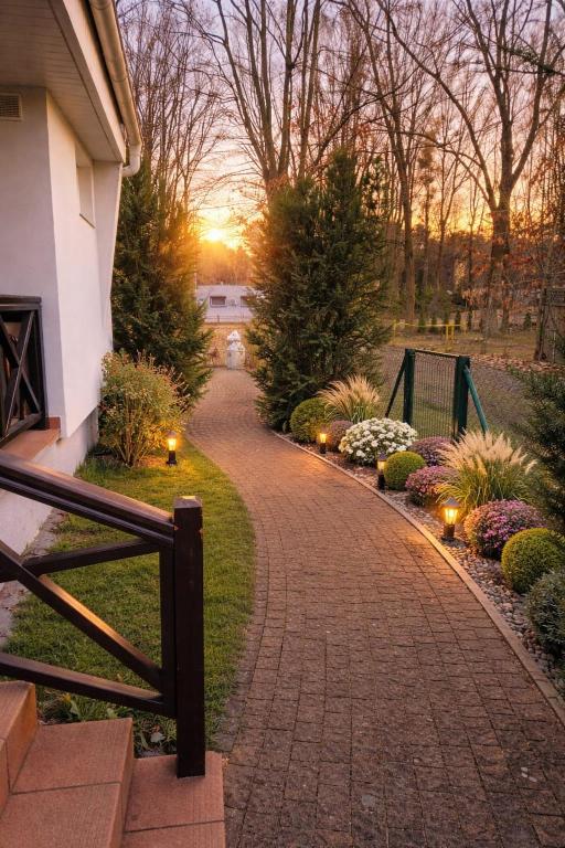 a brick pathway leading to a house with lights at Mierzyn Po Drodze in Mierzyn