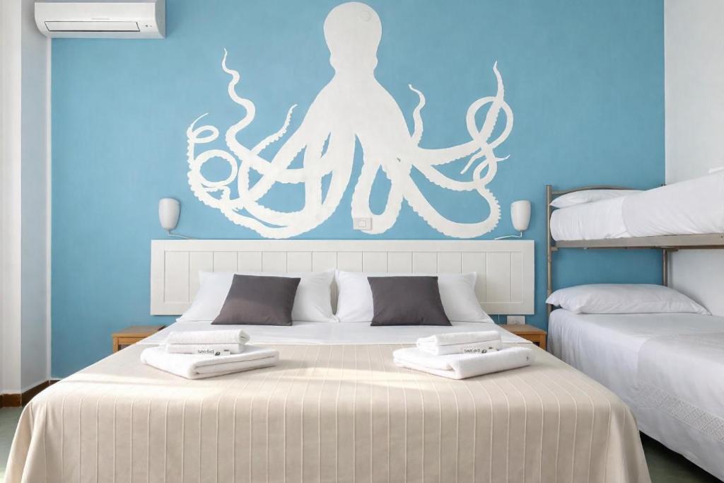 a bedroom with two beds with an octopus on the wall at Hotel Aloha dipendenza Villa Silvie Rose in Cesenatico