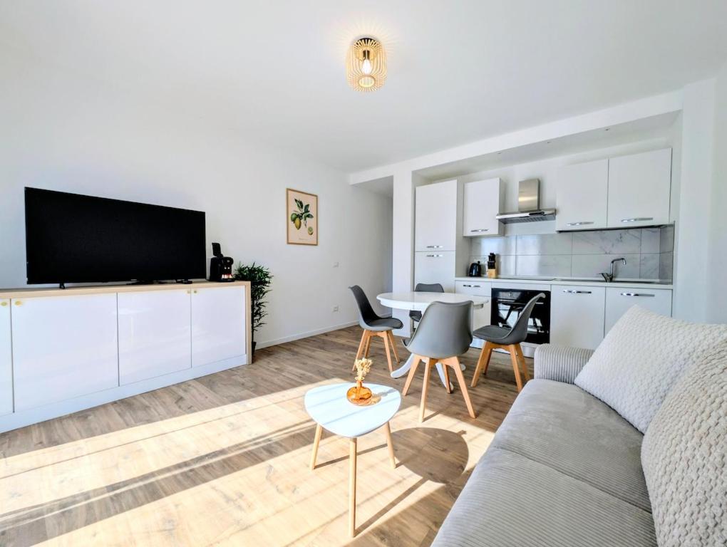 a living room with a couch and a table with chairs at La Régalide 2A in Roquebrune-Cap-Martin