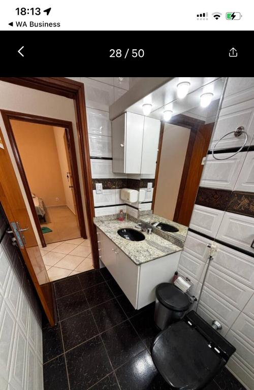 a bathroom with a toilet and a sink and a mirror at KS lazer e eventos in Ribeirão Preto