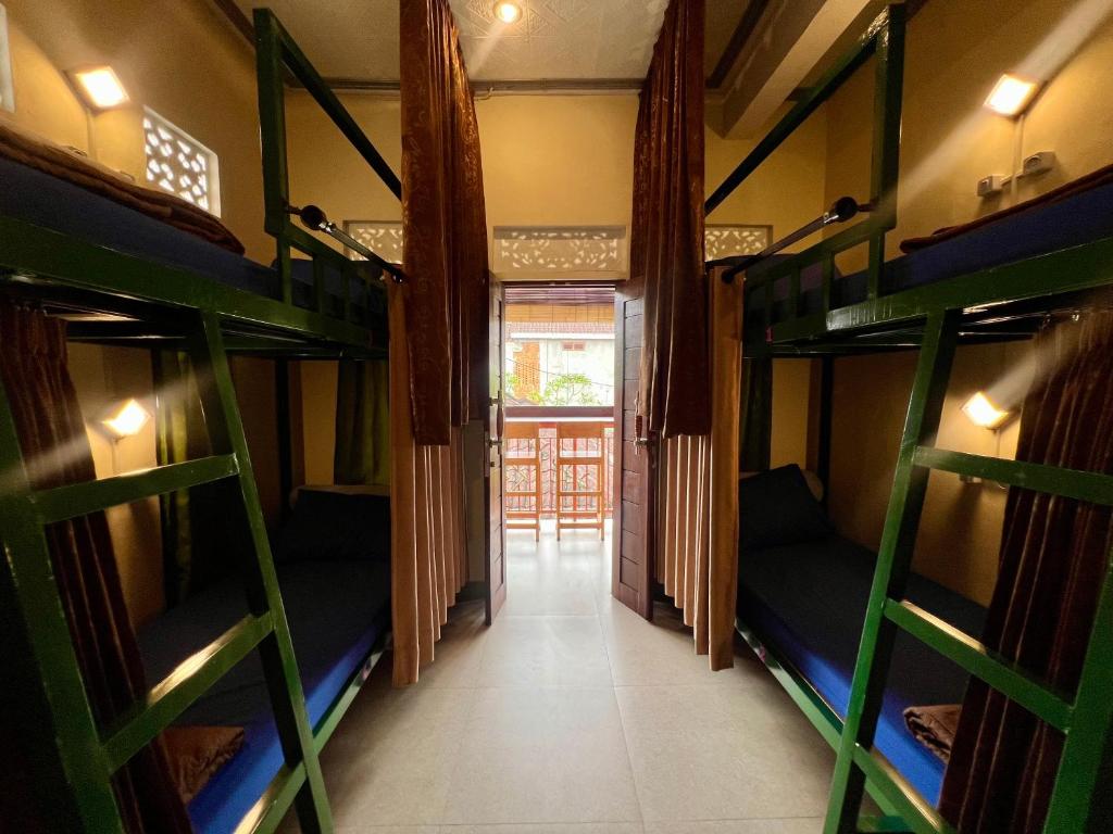 a corridor of a room with bunk beds at ERA Guest House in Ubud