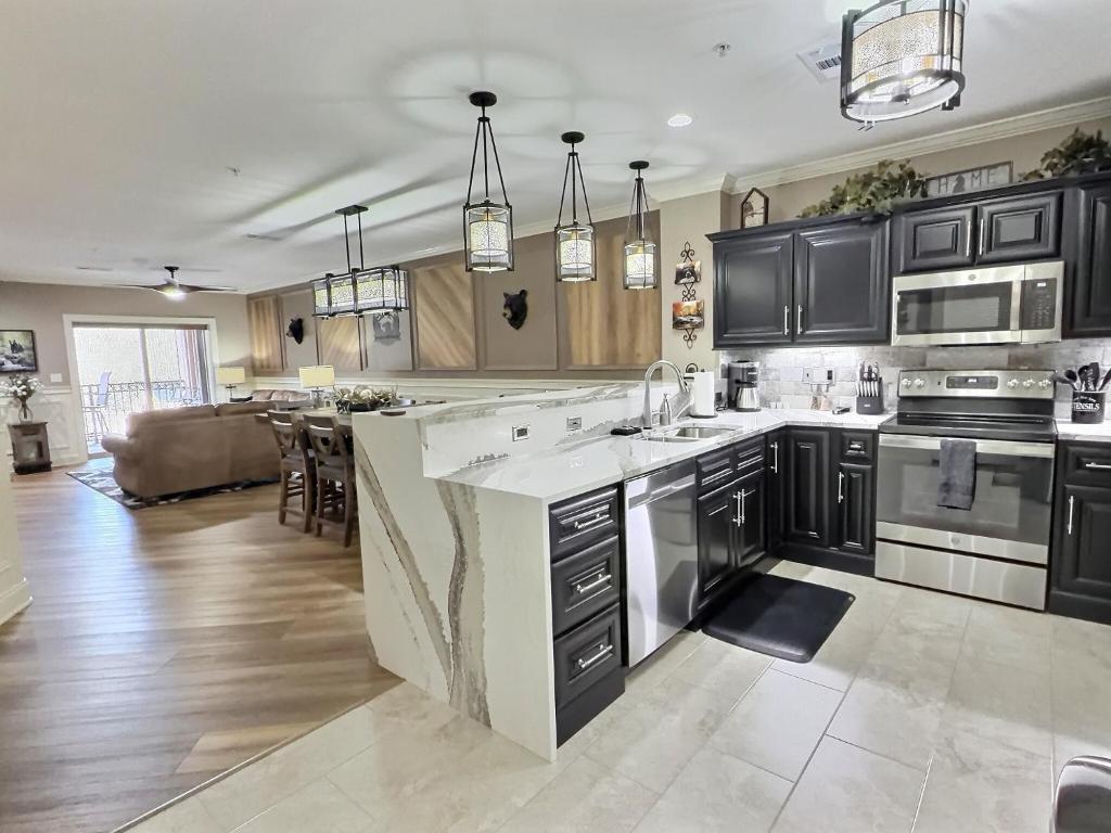 a large kitchen with black cabinets and a kitchen island at Serenity at the Summit in Gatlinburg