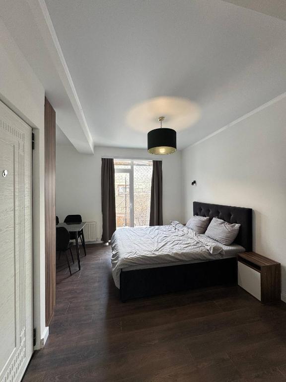 a bedroom with a bed and a large window at Columna Home in Chişinău