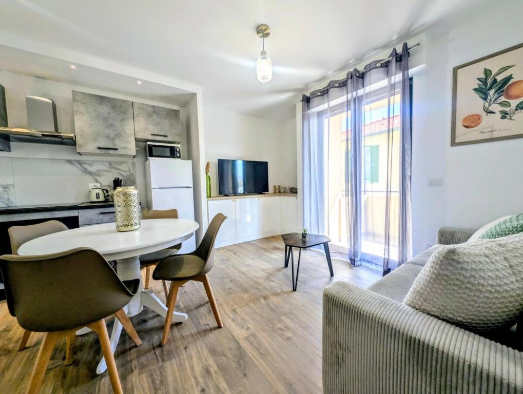 a kitchen and living room with a table and a couch at La Régalide 2 B in Roquebrune-Cap-Martin