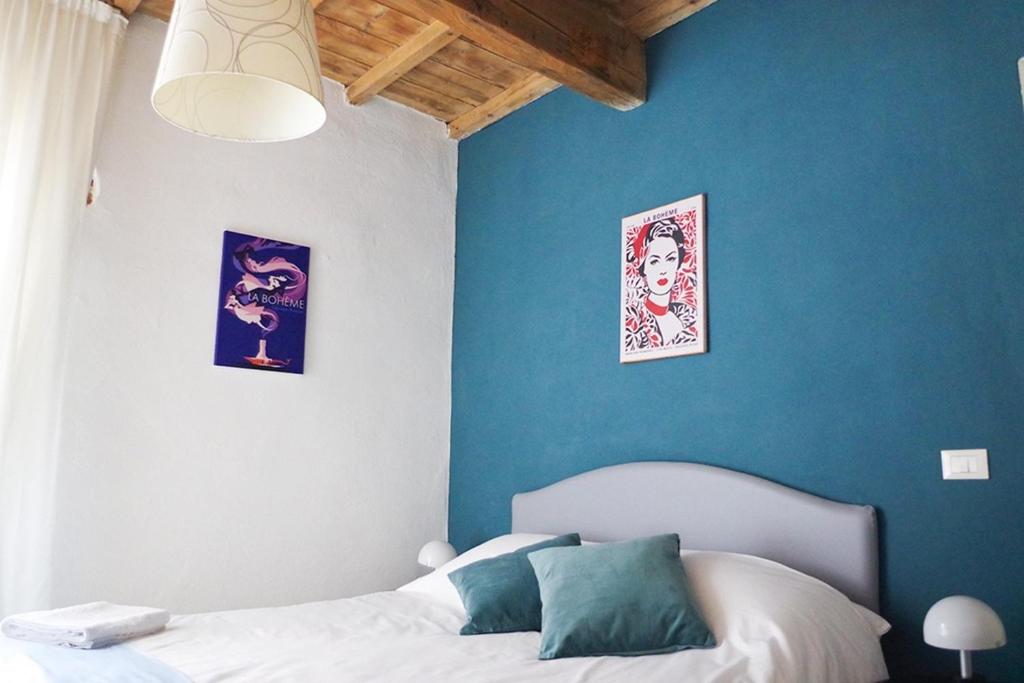 a bedroom with blue walls and a white bed at Residenza Toscanini in Ravenna