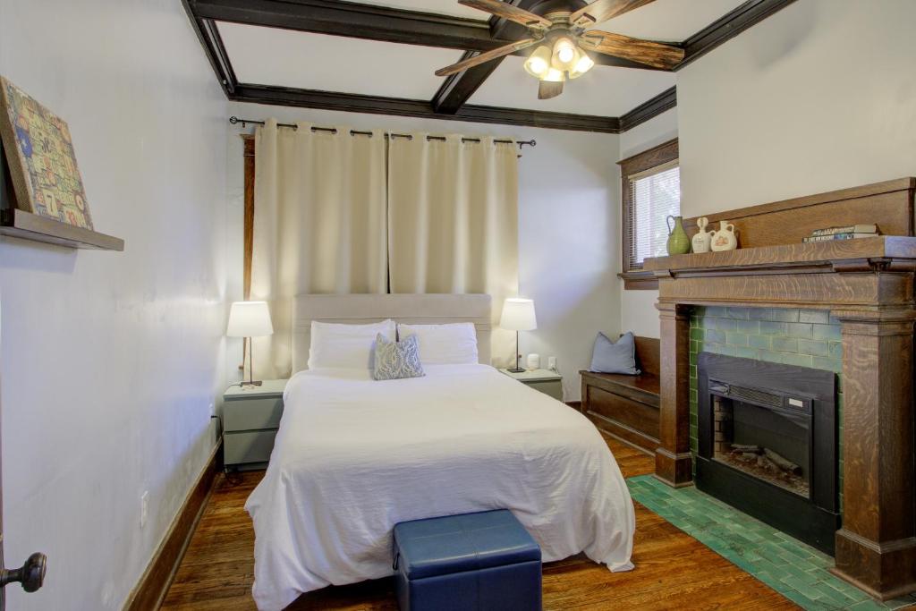 a bedroom with a white bed and a fireplace at Classic Woodwork and Details in 1912 Colonial in Memphis