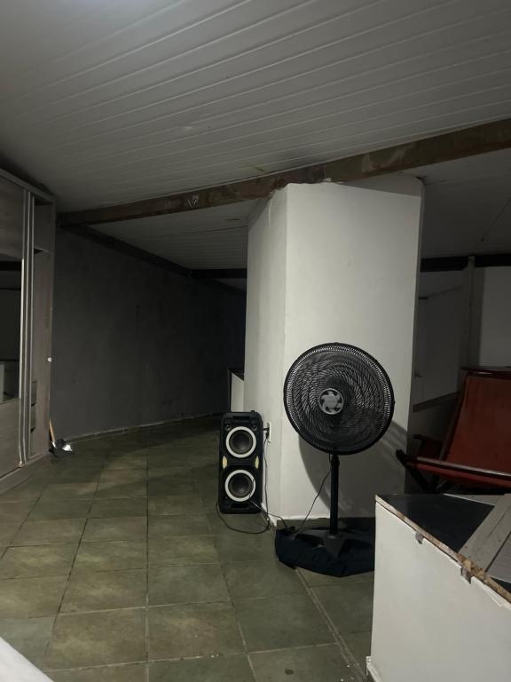 a room with a fan and a speaker in it at Paradise in Natal
