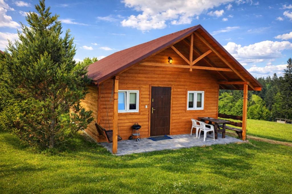 a log cabin with a picnic table in the yard at Domki u Henia i Anety in Werlas