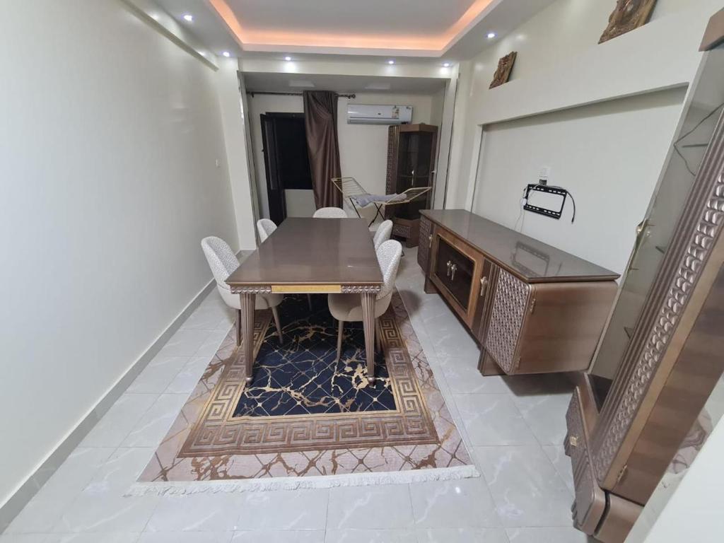 a dining room with a wooden table and chairs at Fatah Apartment 13 in Luxor