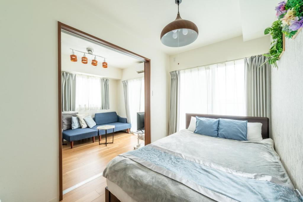 a bedroom with a blue bed and a mirror at The Peak Tengachaya 605 KIX Direct Cozy Elegance near Namba in Osaka