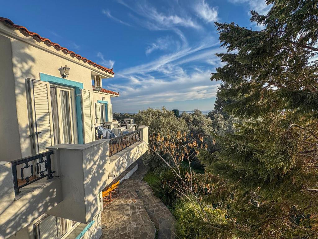 a house with a balcony with a view of trees at Olive Grove House in Kámpos