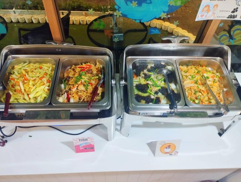 A buffet station with four hot-food trays and labelled dishes.