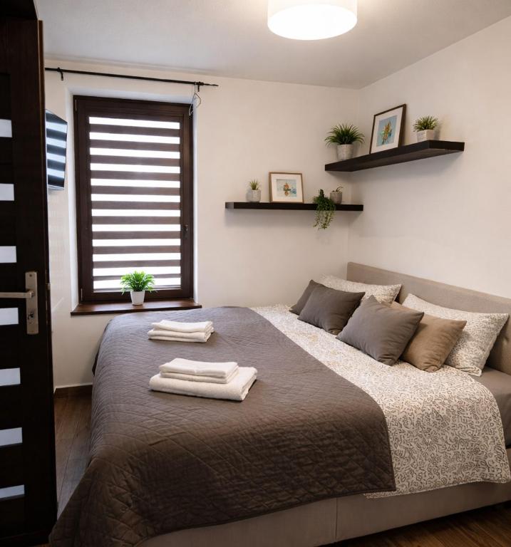 a bedroom with a large bed with two towels on it at 3 Rooms Garden Parking in Raszyn