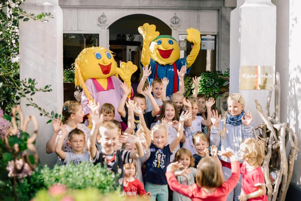 a group of children posing for a picture with mascots at Smileys Kinderhotel in Trebesing
