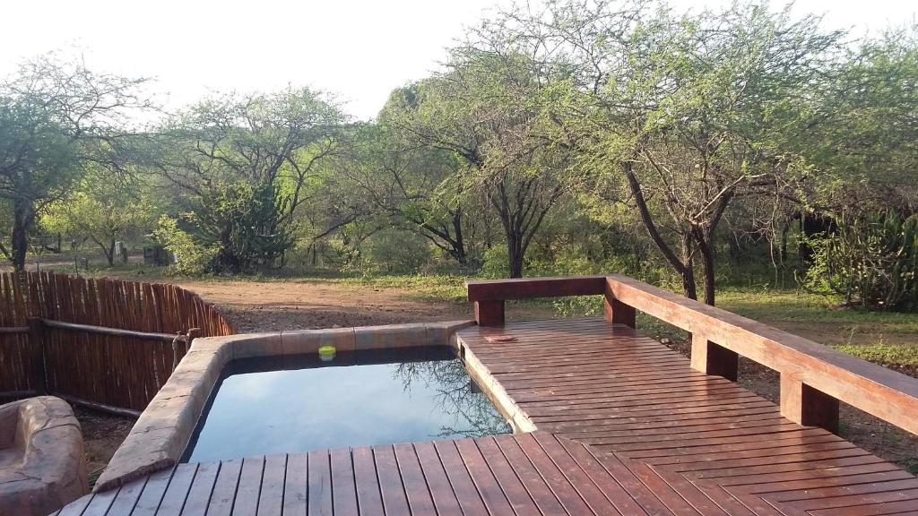 a wooden deck with a pool of water on a wooden bridge at Marloth Kruger Whispering Ants in Marloth Park
