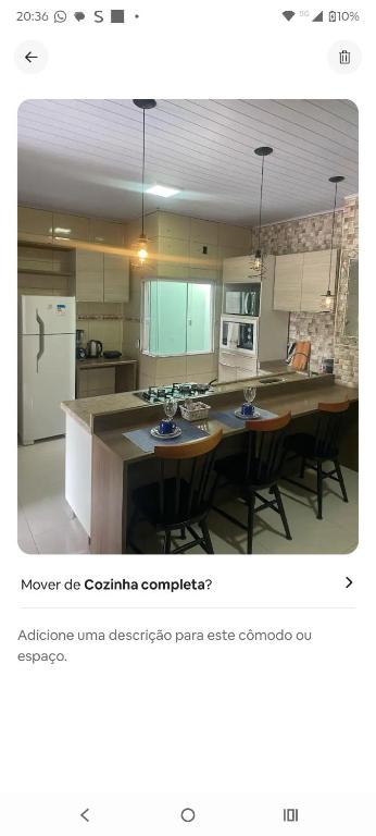 a kitchen with a table and chairs and a refrigerator at Condominio Central Charmoso in Uruguaiana