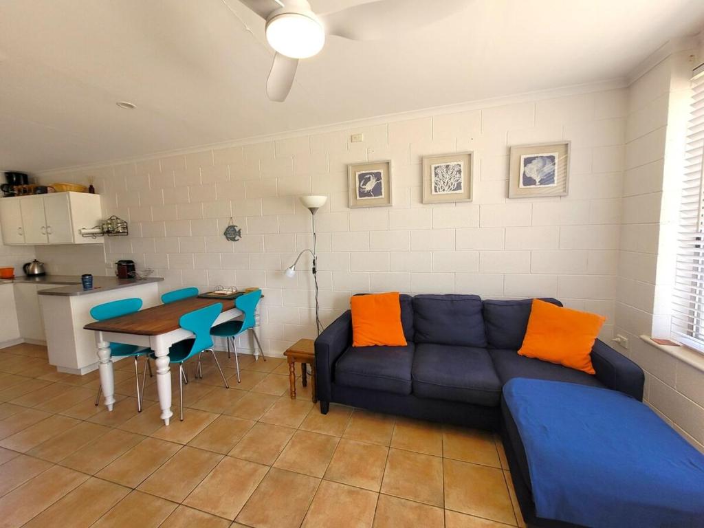 a living room with a blue couch and a table at Baccarat in Port Vincent