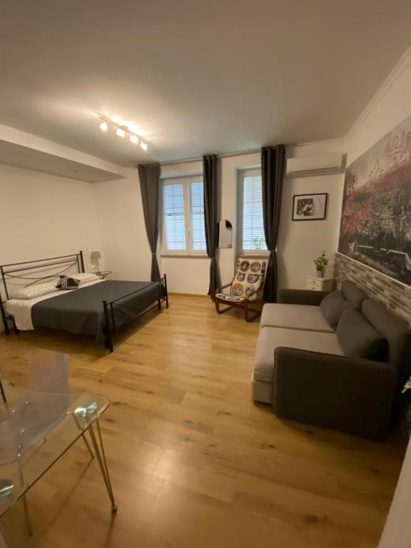 a living room with a bed and a couch at BERNOCCHI ROMA APARTMENT, difronte metropolitana in Acilia