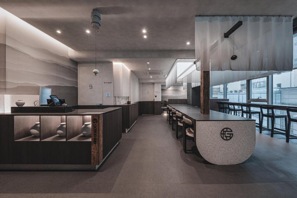 a lobby with a bar and chairs in a building at GOYOO INN & cabins in Seoul