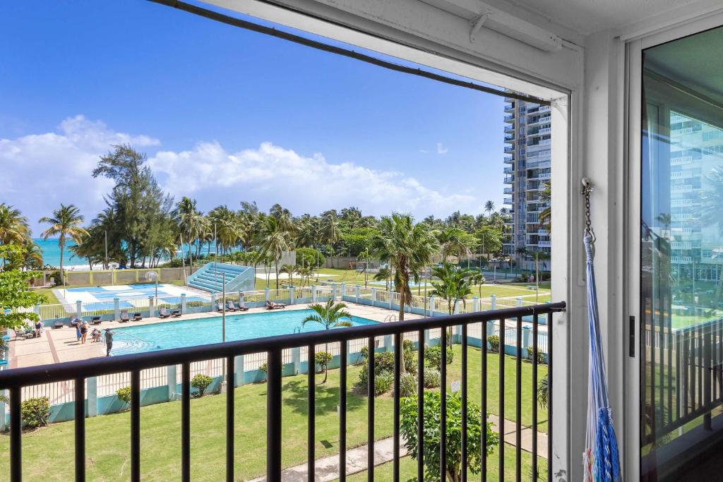 a balcony with a view of a pool and palm trees at Playa Azul Beach by Otium in Luquillo